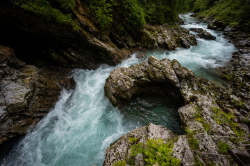 Vintgar Gorges Park a few km from Lake Bled, Slovenia. Wooden walkways accompany the path above the river rapids and waterfalls. River hits rocks and creates fog.Adventure family holidays. Freshness.