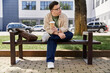© Bliss - A man with Down syndrome sits on a park bench, holding a cup of coffee and gazing off into the distance.