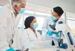 © peopleimages.com - Mask, teamwork and scientist in laboratory with discussion, compliance and safety regulations for experiment. Healthcare, men and woman for medical research, vaccine vial or planning in collaboration