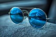 © Leo Rohmann - Blue sunglasses on fabric vibrant and stylish artistic scene inviting setting detailed and creative summer vibes fashionable and fun