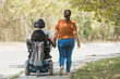 © 24K-Production - Smiling couple holding hands, a man with a disability and his wife on a pleasant autumn walk. Love, care, and marriage concepts.