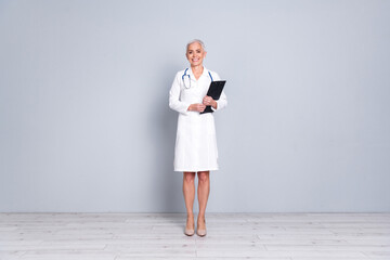 Poster - Full size photo of retired female clinic professional doctor hold paperholder wear white robe uniform isolated on gray color background