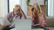 © Yuliia - Angry upset 50s married senior elderly Caucasian couple woman female mature man male businesspeople family bankruptcy business documents paper laptop speak bill money debt problem scam home bad result