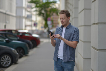 A man on the street using a smartphone. Concept of communication in social networks and messengers.