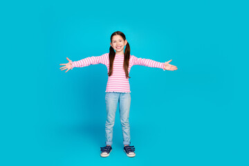 Sticker - Full size photo of friendly small girl with ponytails dressed striped shirt stretching arms to hug you isolated on blue color background