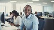 © LukaszDesign - One joyful young African American male contact center telemarketing agent using a headset at an office. Friendly, confident businessman consultant running a customer care helpdesk.