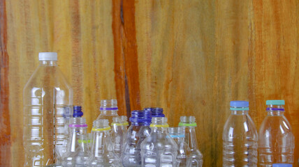 Waste plastic bottles on wooden background waiting for recycling concept of saving our environment sustainable natural resources.