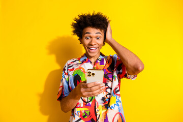 Sticker - Portrait of nice young man touch head use phone wear shirt isolated on vivid yellow color background