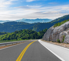 Wall Mural - Country road with rocky mountains in the background.