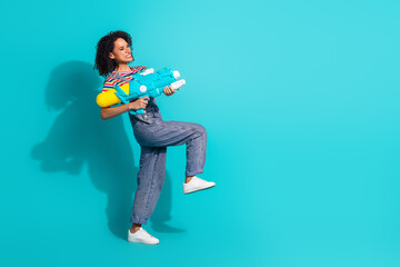 Sticker - Profile side photo of positive smiling girl shooting empty space with water gun isolated cyan color background