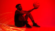 © HockleyM2/peopleimages.com - Basketball, fitness and training with man in red filter lighting for challenge, game or performance. Exercise, long exposure and sports with African person in studio for competition or recreation