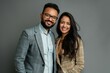 © CogniLens - Portrait of a happy indian couple in their 30s dressed in a stylish blazer in front of blank studio backdrop