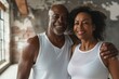 © CogniLens - Portrait of a merry afro-american couple in their 40s sporting a breathable mesh jersey while standing against empty modern loft background