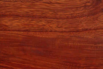 Sapele wood grain features a vibrant, reddish-brown hue with a unique, interlocking texture that creates a striking visual effect, often used for fine furniture and cabinetry due to its durability 