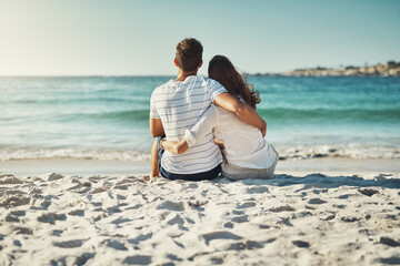 Sticker - Sand, couple and relax on beach for love, commitment and bonding on summer vacation for honeymoon. Man, woman and back view together by ocean for romantic holiday, affection and weekend with embrace.