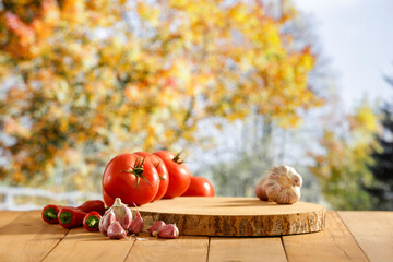 Sticker - Autumn table background with red vegetables  on a garden table with copy space for products.