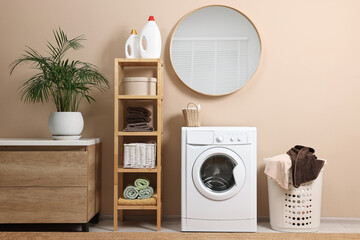 Poster - Stylish laundry room interior with washing machine, furniture, detergents and houseplant