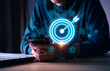 © teerawat - Businessman with target arrow virtual digital technology icon, business investment objectives and goals Marketing strategies and goals for success.