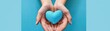 © Media Srock - A person is holding a blue heart in their hands. The heart is made of a material that looks like it is made of plastic