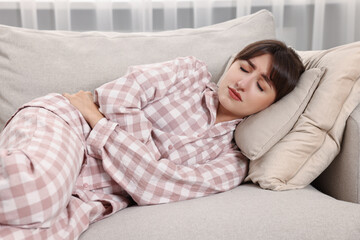 Sticker - Upset woman suffering from abdominal pain on sofa at home