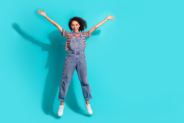 Canvas Print - Photo of positive girl jump raise hands up isolated cyan color background