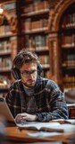 Fototapeta Perspektywa 3d - Handsome European Student Studying in a Traditional Library. Young Male Wearing Headphones, Working on an University Research Project, Reading Academic Textbook and Journals, Generative AI