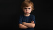 © Maksym - Little boy standing with arms crossed, angrily looking at the camera under studio lights. Annoyed toddler, studio shot, capturing an intense expression of childhood frustration.