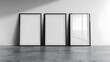 © Abdul - 3 empty vertical picture mockup frames standing next to each other on the floor, blank white canvas