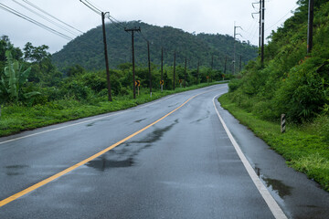 Wall Mural - Wet asphalt road with beautiful view of misty landscape