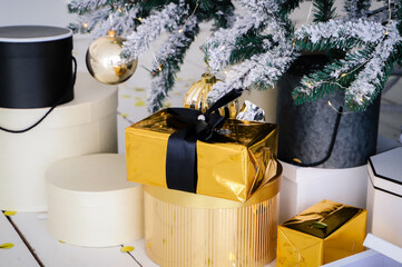 Pink present boxes with ribbons under the Christmas tree in Classic apartments with white interior