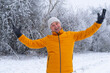 © kittyfly - Happy elderly man in bright yellow jacket enjoying leisurely stroll through picturesque park, surrounded by serene snow-covered landscapes, winter walk, Outdoor Active Lifestyle, frosty weather