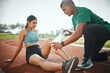 © DavisShared/peopleimages.com - Athletics, injury and people with bandage on track for training, first aid or leg support in sports. Field, runner and paramedic with wrap for outdoor exercise sprain, accident or protection of joint