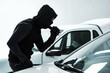 © peopleimages.com - Person, torch and steal car as criminal for burglary activity, illegal crime and transport thief in parking lot. Mask, identity and hijacking access, progress and intrusion of vehicle security risk