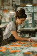 © Ala - A Young Artist's Focused Gaze Upon a Vibrant Floral Print in a Printing Studio