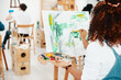 © peopleimages.com - Canvas, hobby and woman with paint, creativity and texture with motivation, inspiration and ideas in studio. People, back and girl with tools, stress relief and watercolor in workspace or abstract