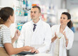 © JackF - Kind male druggist and his female assistant choosing medicine for client showing recipe sheet in chemist's shop