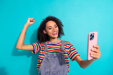 Sticker - Photo of positive excited girl use cell phone raise fists up isolated blue color background