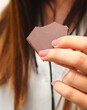 © Natalia Brand - A woman is holding a piece of chocolate in her hand