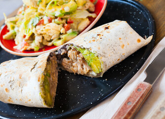 Wall Mural - Mexican cuisine. Plate with chicken salad with avocado and burrito with tuna