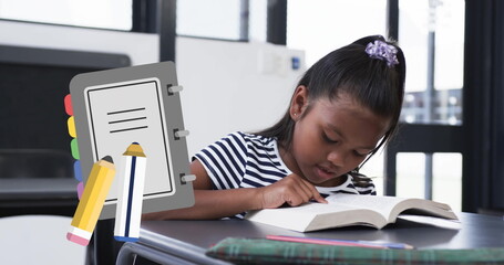 Poster - Studying at desk, young girl reading book with notebook and pencil image