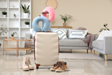 Sticker - Suitcase with neck pillows and boots in room. Travel concept