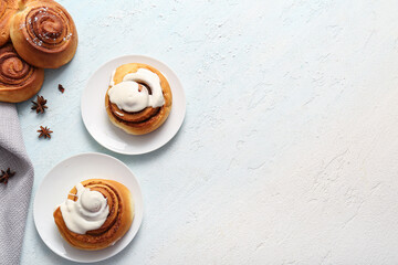 Wall Mural - Plates of sweet cinnamon rolls with glaze on light blue background