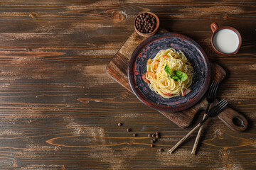 Sticker - Plate with tasty pasta carbonara, cutlery and tray on wooden background