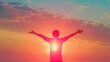 © VISUAL BACKGROUND - A person standing with their arms outstretched at sunset.