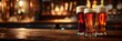 © Elmira - Three glasses of beer sit on a wooden bar counter in a dimly lit pub