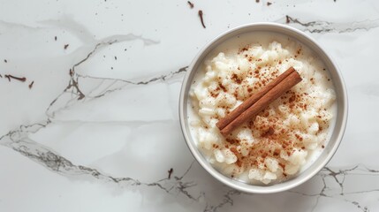 Arroz con leche Rice pudding with cinnamon in bowl on white marble Top view Copy space