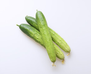 Poster - Close up of three stacked raw green cucumbers on white floor, South Korea
