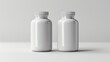 © Nano Photos - Two white, opaque bottles with white caps are placed side by side on a plain surface against a neutral background.