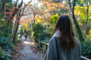 Wall Mural - a woman walking down a path in the woods