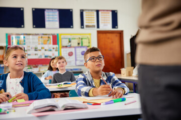 children listening to teacher in classroom